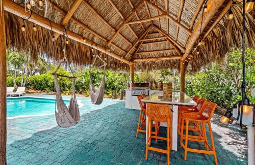 Garden Isles House | Eccentric home with pool tiki hut & outdoor kitchen