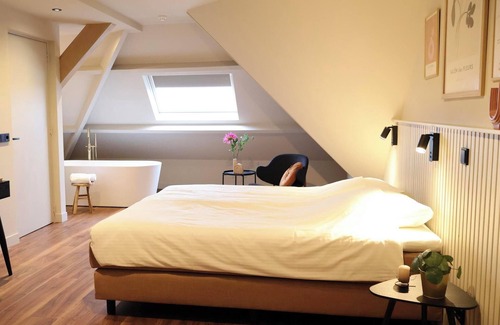 Appeltern Hotel | Luxurious family suite with river meadow views, a bathtub, and modern amenities for a relaxing family getaway.