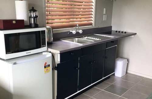 Whangaroa Ski Chalet | One Bedroom Unit with bathroom and small living area with kitchenette.