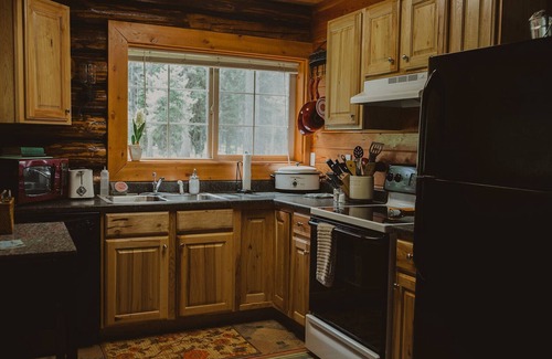 Seeley Lake Cabin | The Saddle Shed at Tamaracks Resort is a log cabin with furnished screen porch.