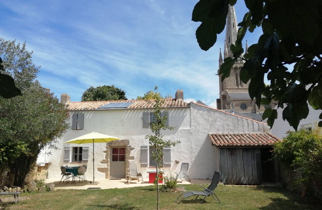 a charming little house deep in a fenced garden with stone walls