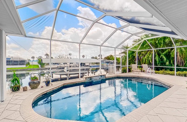 Dog-friendly waterfront home with heated pool, lanai, central AC, & W/D