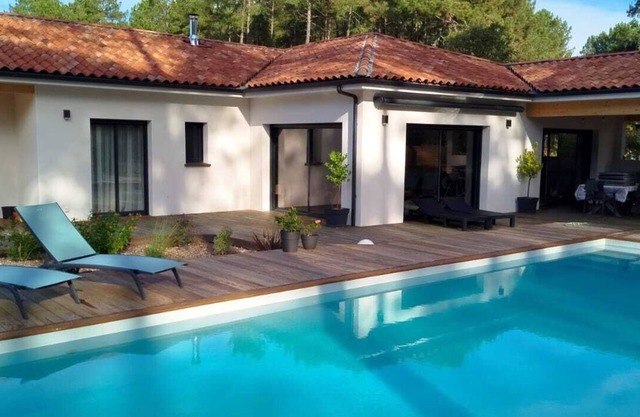 Modern villa with pool near the ocean and forest edge