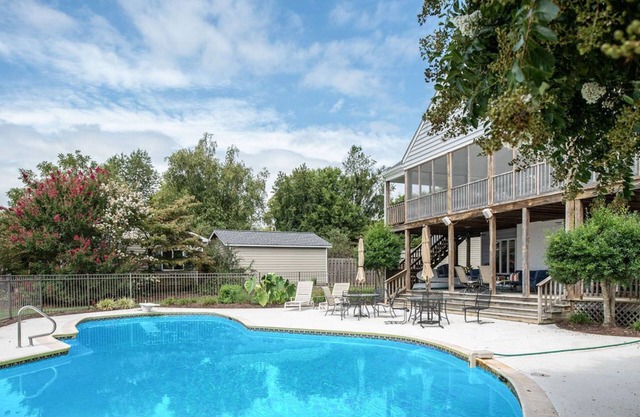 Waterfront home with swimming pool and tennis court.