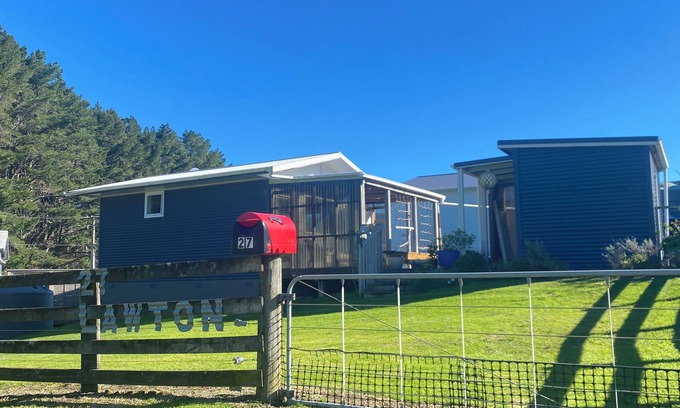 Kawhia Cottage | Cosy Aotea Cottage with water views, a gentle stroll to the beach. Pet Friendly!