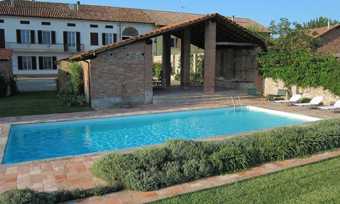 Incisa Scapaccino House | Farmhouse with swimming pool surrounded by greenery