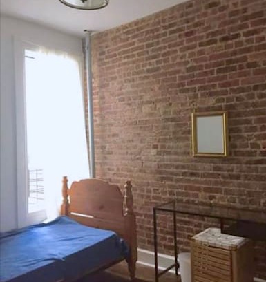 Bedford-Stuyvesant Apartment | Beautiful room with a brick wall
